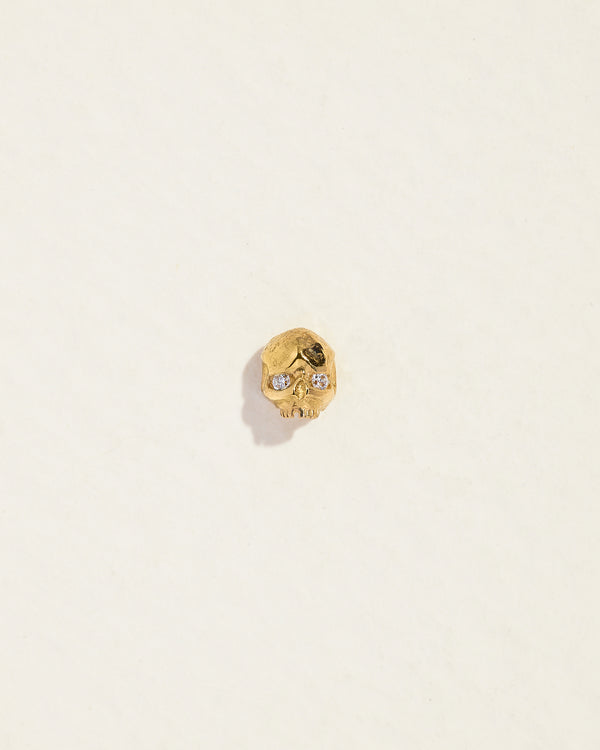 gold skull stud piercing with diamond eyes