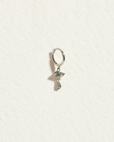 Front view of a crying eye huggie earring with an emerald eye and dangling teardrop accent