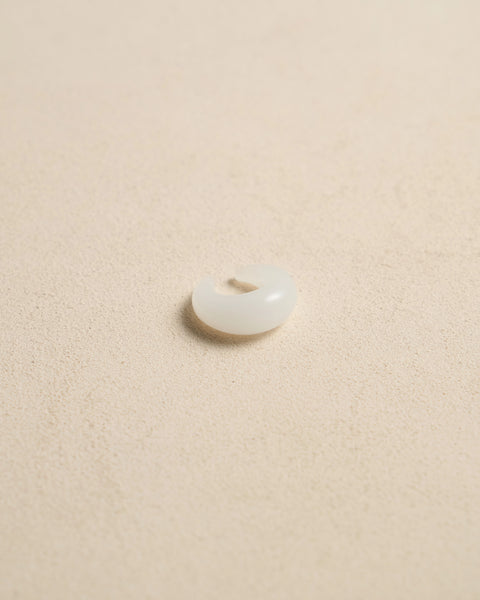 Borosilicate white glass dome ear cuff, approx. 20mm outer diameter, close-up showing rounded C-shaped profile