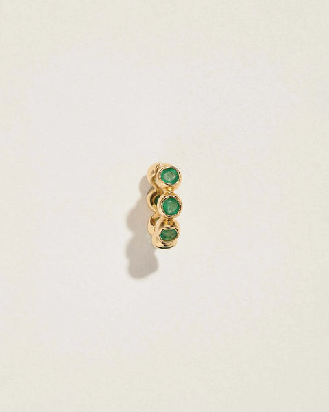 Molten Stone Huggie by Pamela Love – Piercing in #product_material# (#product_color#).  emerald-molten-huggie-gold-emerald-green