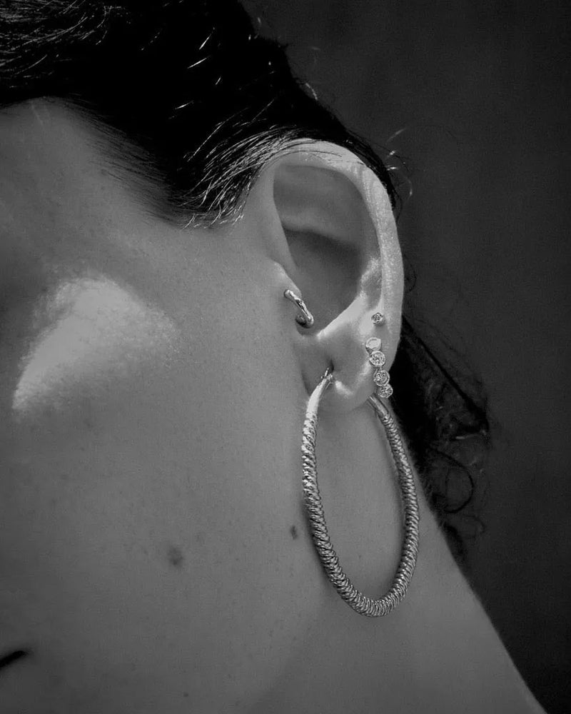 Molten Stone Huggie by Pamela Love – Piercing in #product_material# (#product_color#). 