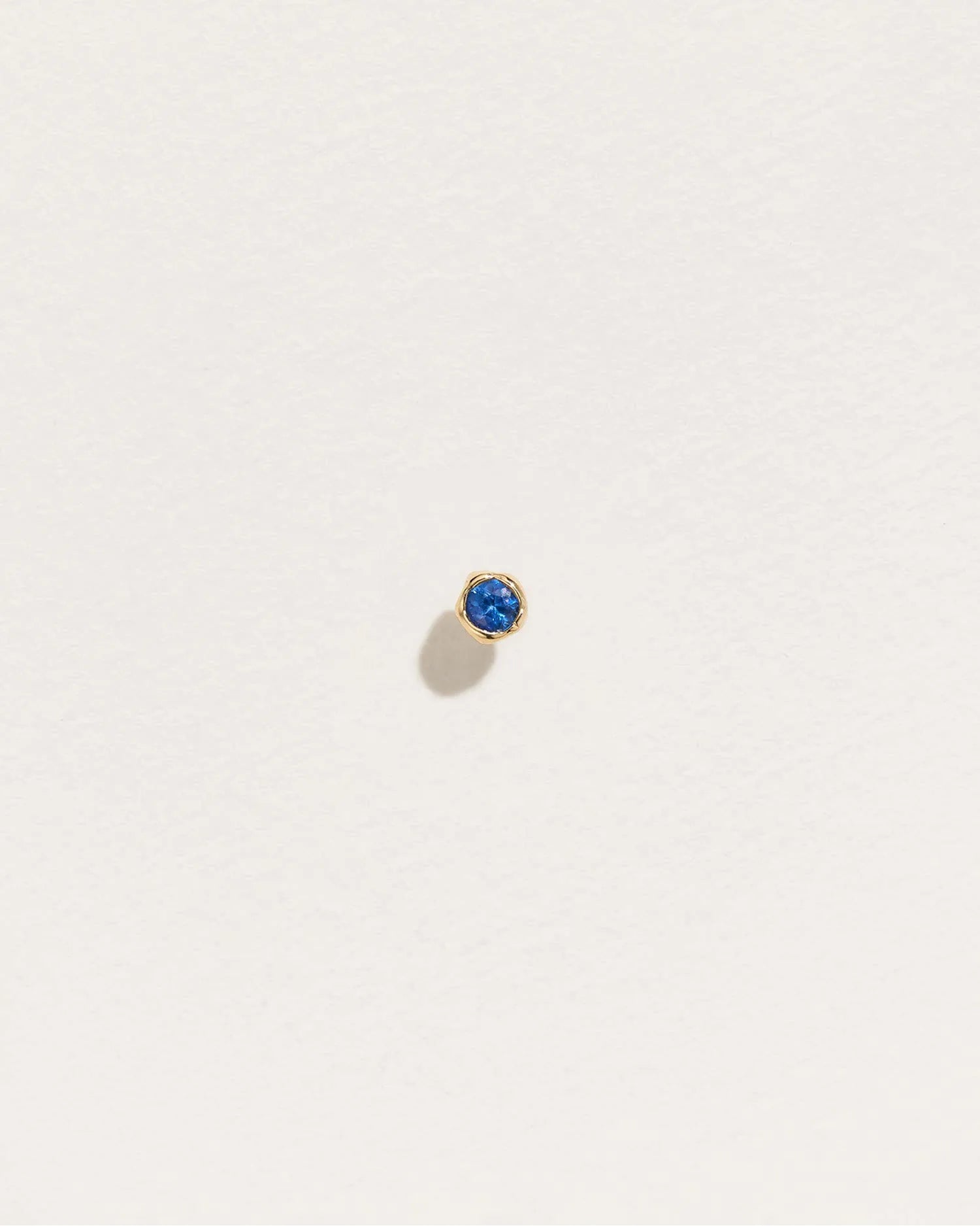 Petite Nugget Stud by Pamela Love – Piercing in #product_material# (#product_color#).  petite-nugget-stud-gold-sapphire-blue