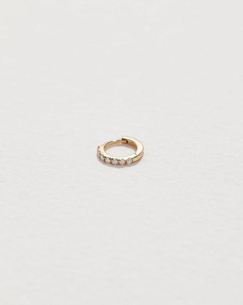 Tiny Half Pavé Huggie by Pamela Love – Piercing in #product_material# (#product_color#).  tiny-half-pave-huggie-gold-diamond-white