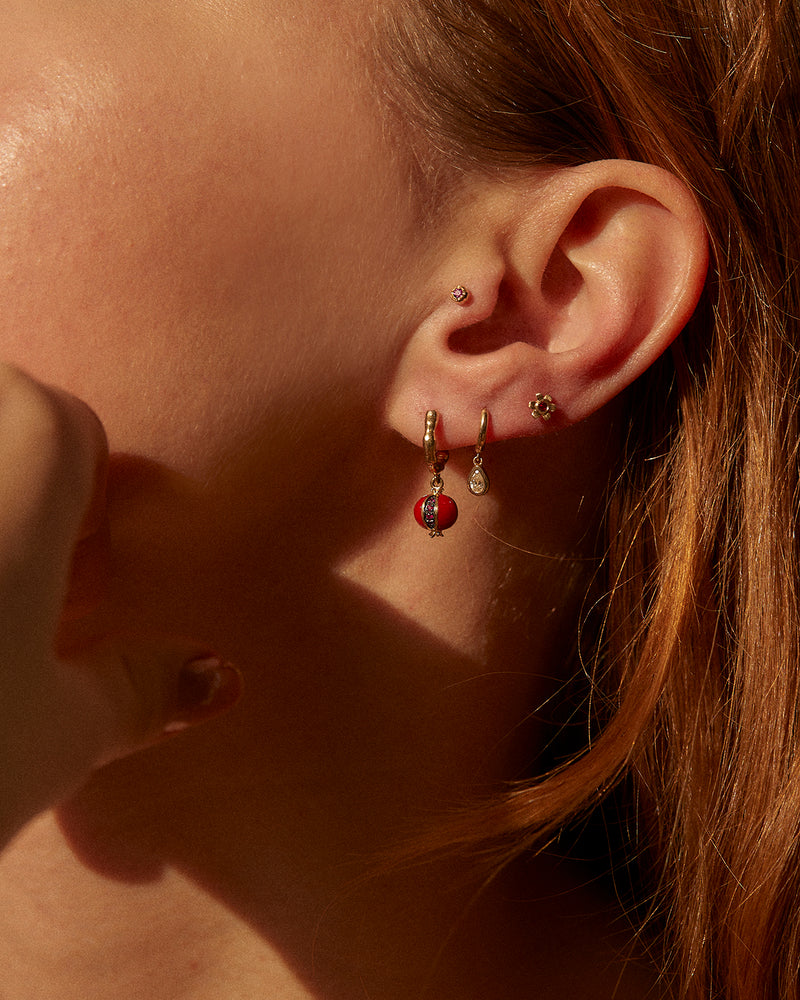 ruby pomegranate huggie earring on the model