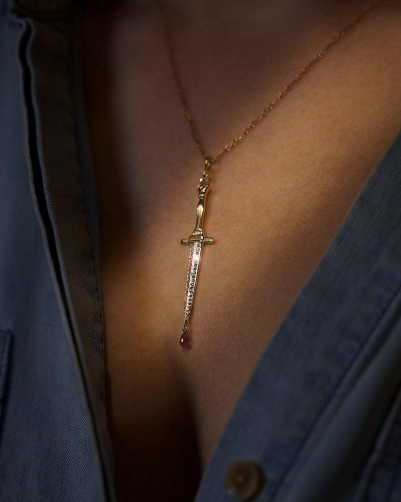 gold dagger pendant necklace on the model