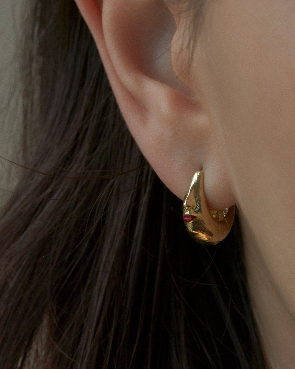 womans face gold hoop earring