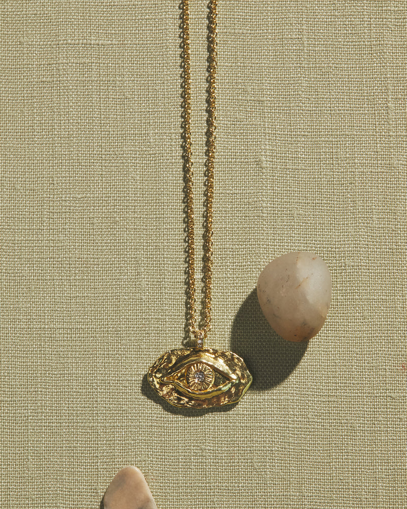golden eye pendant with diamond in the center