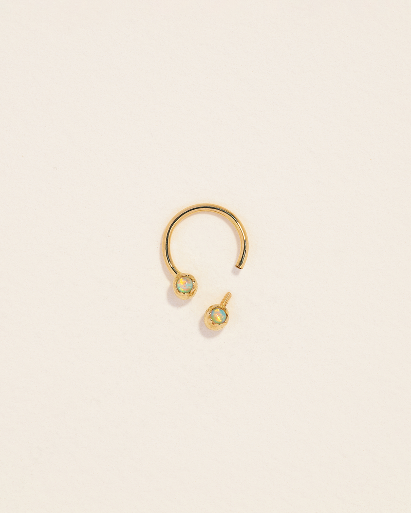 gold circular barbell piercing with 2 opals
