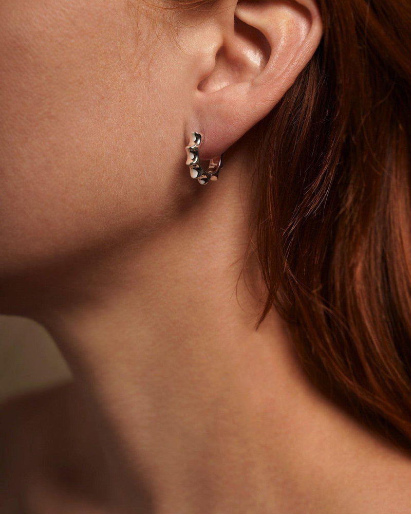 silver sun hoop earrings on the model