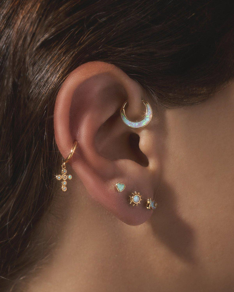 diamond opal cross huggie earring on the model