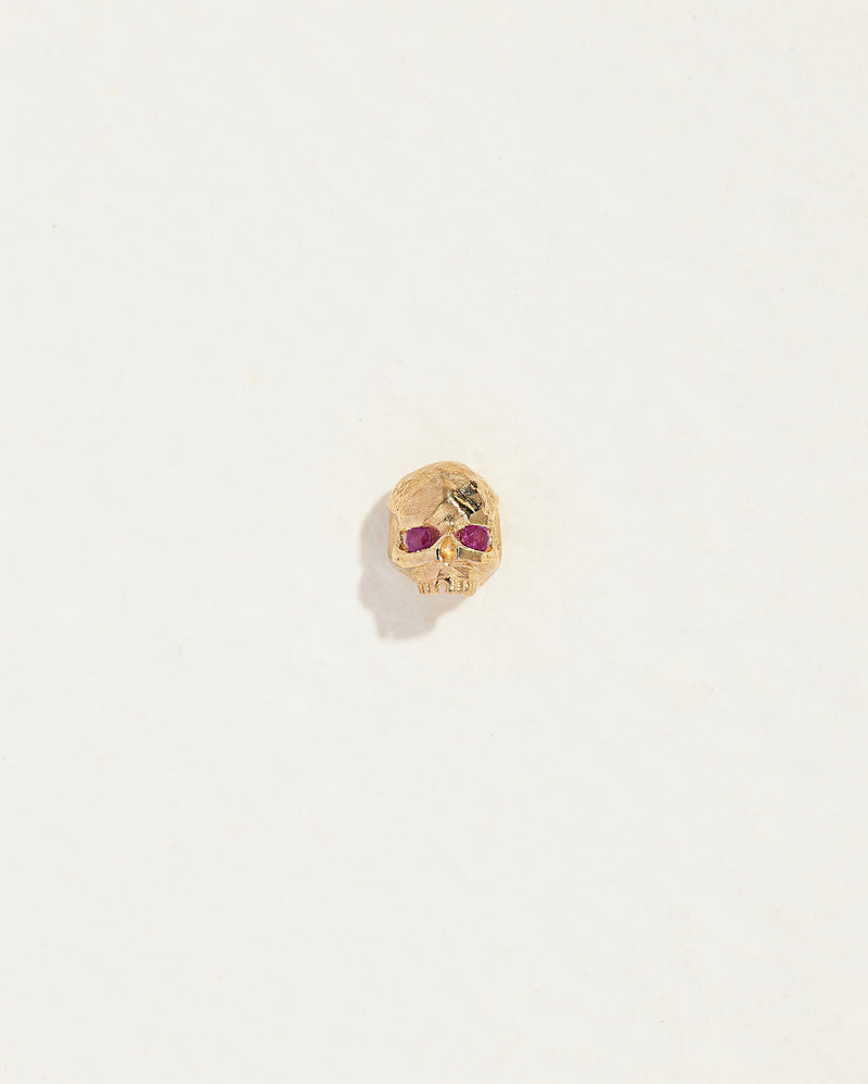 gold skull stud earring with ruby eyes