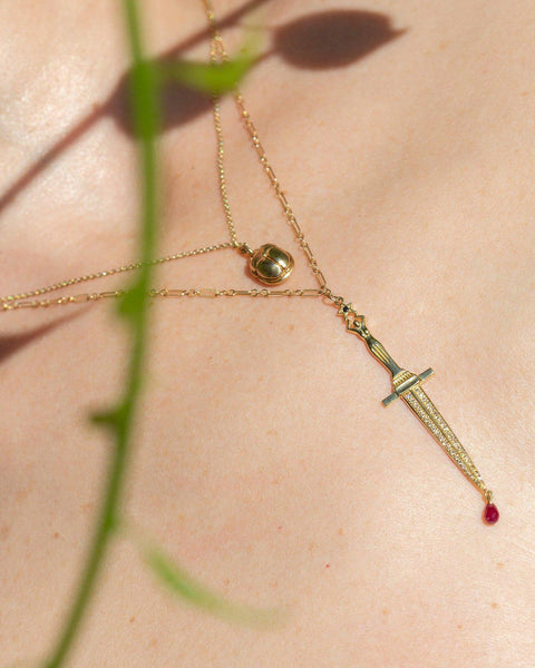gold dagger pendant with ruby