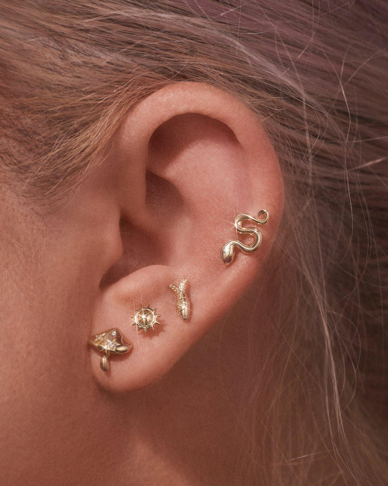 pamela love gold stud piercings on the model